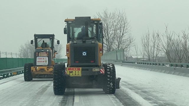 2月21日，六安西中心除雪小組在周集往南照方向用裝載機進行梯隊除雪作業.jpg