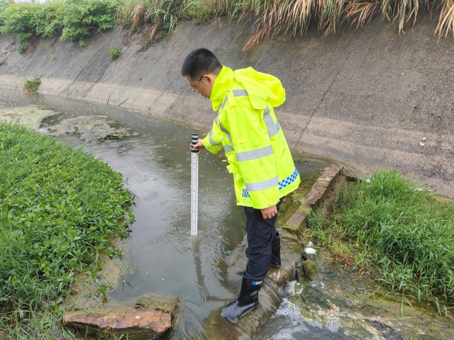 16蕪湖管理中心繁昌站收費班長吳孫軍測量收費站辦公樓附件河水水位.jpg